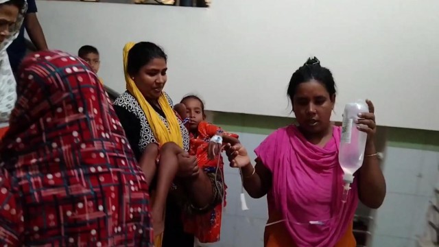 A mother carries her ailing child in her arms at Mugda Medical College Hospital due to the unavailability of a stretcher, as the facility struggles to cope with the growing influx of dengue patients. (Photo: Ali Hossain Mintu/V7N)