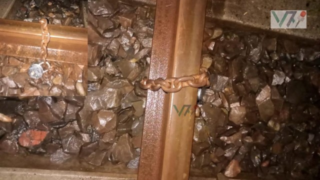 Police and railway officials inspect a section of the track near Madhnagar Railway Station in Natore on August 3, 2025, where a locked iron chain was found wrapped around the rail in an apparent attempt to derail a train.
