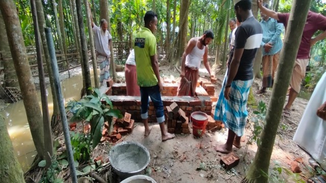 Residents construct raised graves using bricks and sand in waterlogged Mirukhali, Mathbaria, where illegal dams have left no dry ground for traditional burials.