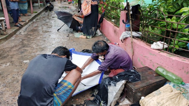 A local repair worker fixes a broken umbrella at a bustling market in rain-soaked Durgapur. (Photo: V7N)