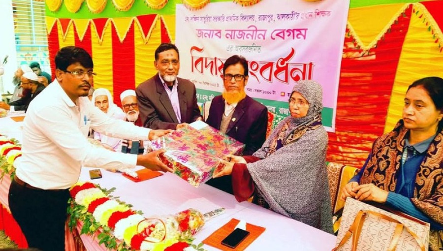 Nazneen Begum, the retiring headmistress of Saturia Government Primary School in Rajapur, is honored by colleagues and community members during a heartfelt farewell ceremony.